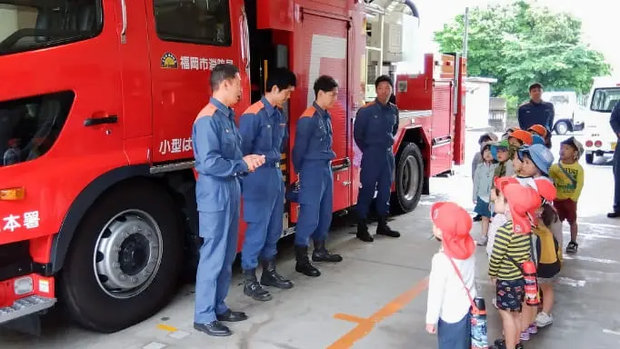 消防車の前で整列する園児