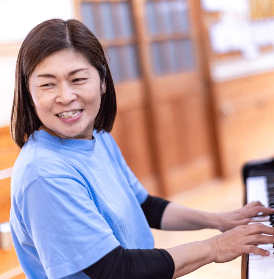 ピアノを弾く笑顔の主幹保育教諭