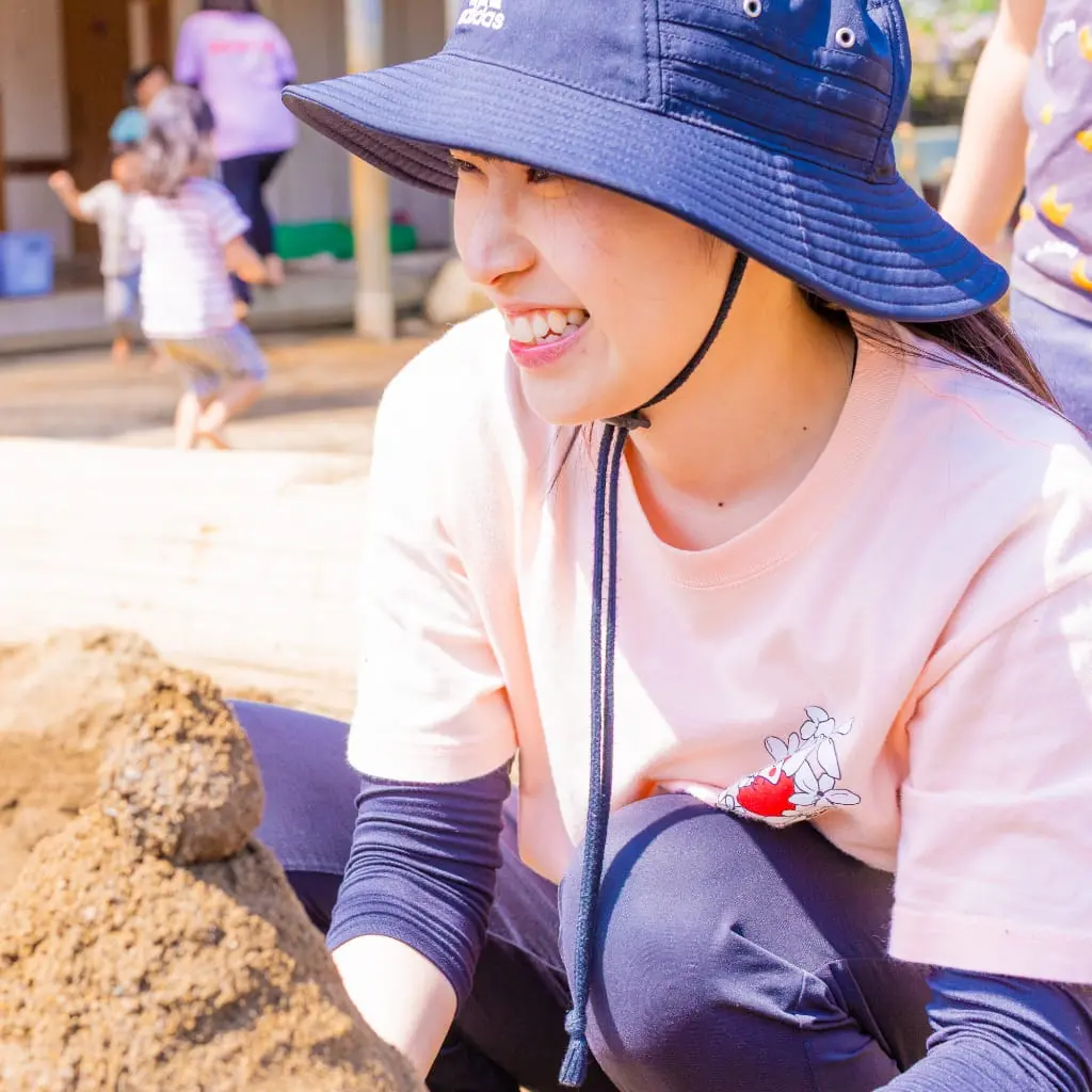 園庭で土を掘る保育教諭