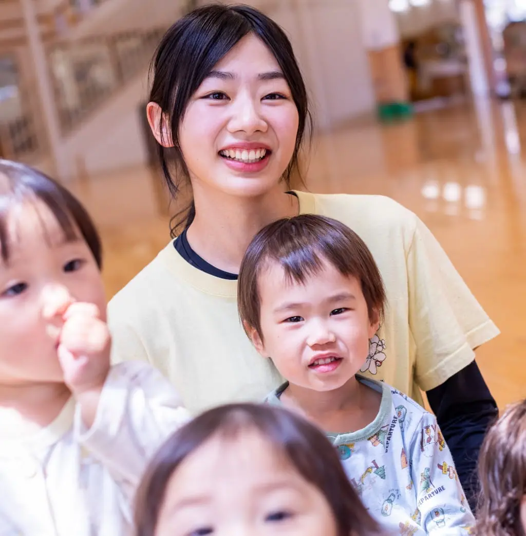 体育館で子供と遊ぶ保育教諭