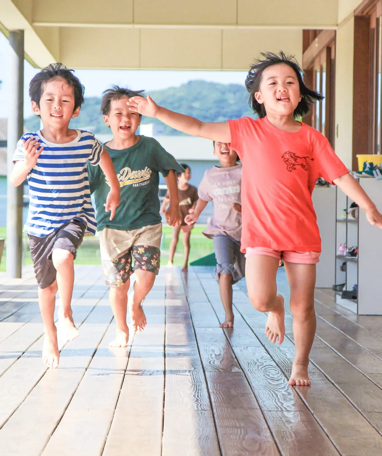 園の廊下で元気に遊ぶ子どもたちの写真